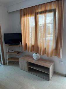 uma sala de estar com uma janela e um vaso sobre uma mesa em Nantia Apartment em Myrina
