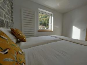 Schlafzimmer mit einem großen weißen Bett und einem Fenster in der Unterkunft Thon chez toi in Andenne
