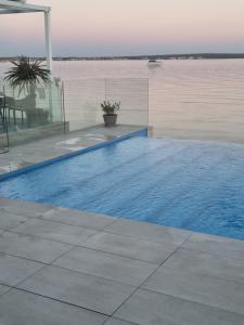 a swimming pool with a view of the water at Arcadia - Beach villa n.1 in Privlaka