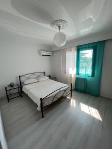 a white bedroom with a bed and a window at Nantia Apartment in Myrina