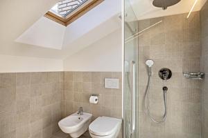 a bathroom with a shower and a toilet and a sink at Appartamento Confolia 2 in La Valle