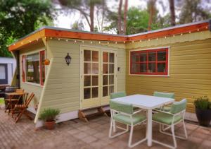 a tiny house with a table and chairs on a patio at The Sunbird Inn - with luxurious bathroom in Diessen