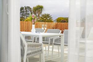 a white table and chairs with a vase on it at St Moritz Hotel and Cowshed Spa in Polzeath