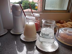 a counter with two glasses of milk and a pitcher of water at Pousada Amar Lençóis Turismo in Barreirinhas