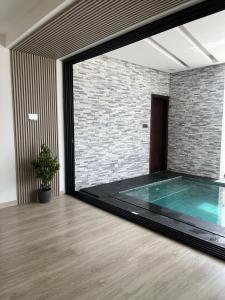 una piscina en una habitación con una pared de ladrillo en AB Villa en Ajman 