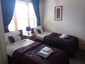 a room with two beds with towels on them at Aviemore Glenlivet Lodge in Aviemore