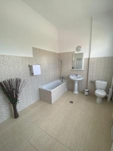 uma casa de banho com uma banheira, um WC e um lavatório. em Pensiunea Viena em Târgu-Mureş