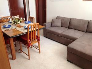 sala de estar con mesa y sofá en Casa a Gallipoli a 1 minuto dal mare en Gallipoli