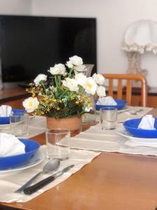 una mesa con platos azules y blancos y flores en ella en Casa a Gallipoli a 1 minuto dal mare en Gallipoli