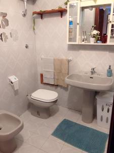 a white bathroom with a toilet and a sink at Casa a Gallipoli a 1 minuto dal mare in Gallipoli
