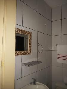 a bathroom with a mirror and a sink at Pousada Amar Lençóis Turismo in Barreirinhas