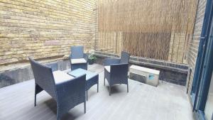 a patio with chairs and a table and a heater at Spacious 3 Bed Flat near Liverpool street, Spitalfields in London