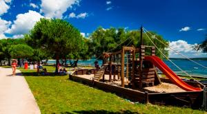 un parque infantil en un parque junto al agua en Emonia apartman, en Novigrad Istria