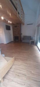 a large room with a wooden floor and a couch at Agroturystyka Kluki u Tosi in Smołdzino
