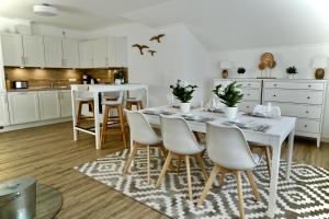 een witte keuken met een witte tafel en stoelen bij MyHome Ruegen - Haus Sonnenmeer in Ostseebad Sellin