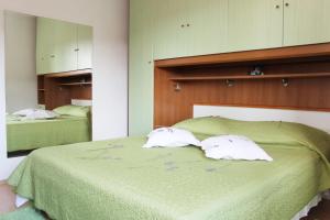 ein Schlafzimmer mit zwei Handtüchern auf einem grünen Bett in der Unterkunft Apartments Ruza vjetrova in Postira