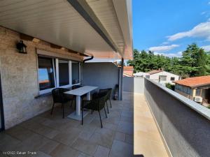 Un patio con una mesa y sillas en un balcón. en Emonia apartman, en Novigrad Istria