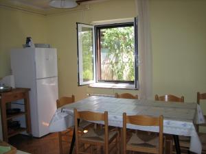 a kitchen with a table and a refrigerator and a window at Apartma Janja in Portorož