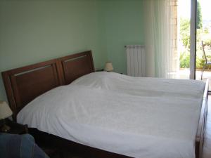 a bedroom with a bed with white sheets and a window at Apartma Janja in Portorož