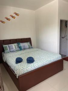 twee blauwe hoeden op een bed in een slaapkamer bij Kalae Resort in Ban Nong Ben