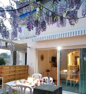 a patio with a table and chairs and purple flowers at VERDON GRAN VALA 2 les pieds dans l'eau in Martigues