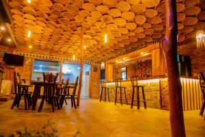 a bar with wooden chairs and tables in a room at Akagera Transit Lodge in Akagera