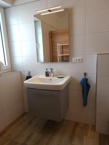 y baño con lavabo y espejo. en Haus JADEHUUS, en Schweiburg