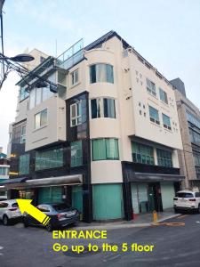 a building on a street with cars parked in front of it at Dolma Hongdae in Seoul