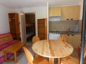 a kitchen and dining room with a wooden table and chairs at Appartement typique de montagne in Thollon