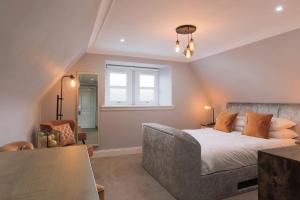 a bedroom with a bed and a couch and a window at The Lovat, Loch Ness in Fort Augustus