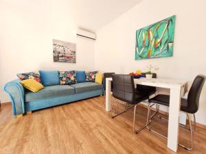 sala de estar con sofá azul y mesa en Apartment Morska oaza, en Klenovica