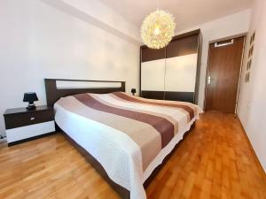 Un dormitorio con una cama grande y una lámpara de araña. en Apartment Morska oaza, en Klenovica