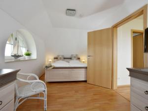 a bedroom with a bed and a chair in a room at Villa Fasan in Trent