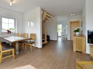 a dining room with a table and chairs and a television at Villa Fasan in Trent