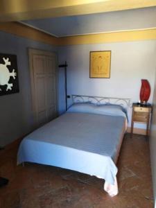 a bedroom with a bed with a blue bedspread at Appartamento incantevole ad Armeno in Armeno