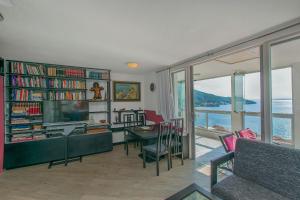 a living room with a table and a library with a view of the ocean at Apartments Sonja in Igrane