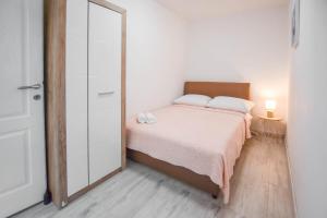 um pequeno quarto com uma cama e um espelho em Apartments Toni em Poljana