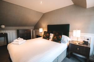 a bedroom with a large white bed with two lamps at The Seafield Arms-Cullen in Cullen