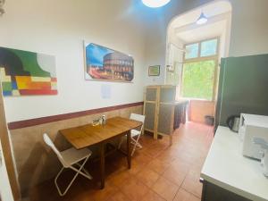 une cuisine avec une table et des chaises dans une pièce dans l'établissement ROMA GONDOLA SRLS, à Rome