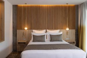 1 dormitorio con 1 cama blanca grande con almohadas en Villa Castellane, en Gréoux-les-Bains