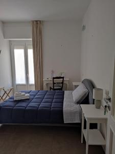 - une chambre avec un lit bleu et une table dans l'établissement B-KARALIS DI ENRICO TUPPUTI, à Cagliari