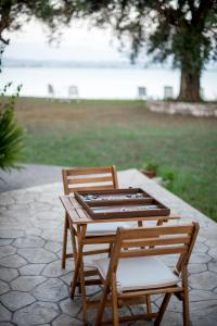 duas cadeiras de madeira e uma mesa e uma mesa e cadeiras em Kiani Akti Villas em Preveza