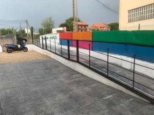 a motorcycle parked next to a colorful fence at ALOJAMIENTOS AVICHE 6 in Santander