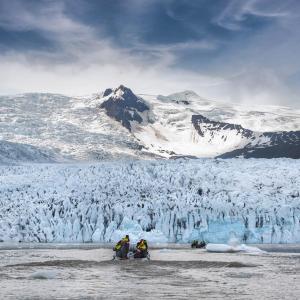 un grupo de personas de pie frente a un glaciar cubierto de nieve en Fjallsarlon - Overnight adventure en Hof