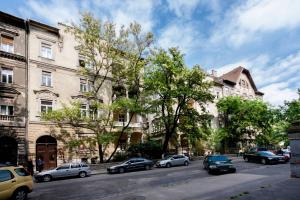 Heroes Square & City Park Thermals Apartment في بودابست: شارع فيه سيارات تقف امام المباني