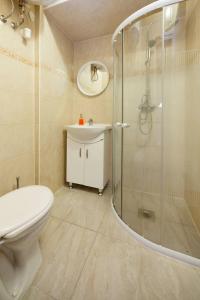 ein Bad mit einer Dusche, einem WC und einem Waschbecken in der Unterkunft Heroes Square & City Park Thermals Apartment in Budapest