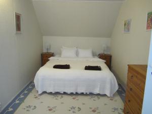 a bedroom with a white bed with two towels on it at Tüve apartment in Kärdla