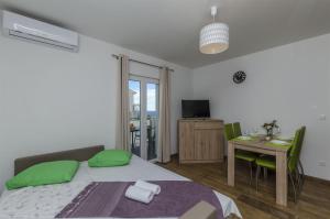 a bedroom with a bed with green pillows and a table at Apartments Lorenzo in Lokva Rogoznica +88 photos