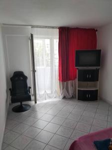 a room with a tv and a chair and a window at Lacul Tei Residence in Bucharest