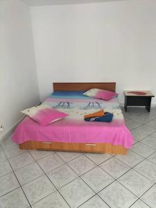 a bedroom with a bed with a pink blanket at Lacul Tei Residence in Bucharest